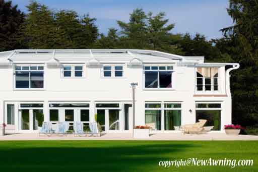 large white house with patio and fancy green green lawn