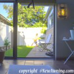 view into backyard through sliding patio door with stone walk way