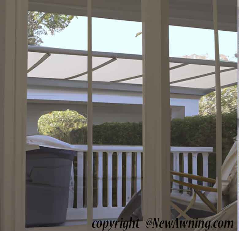 view of patio with trashcan through windows with shade