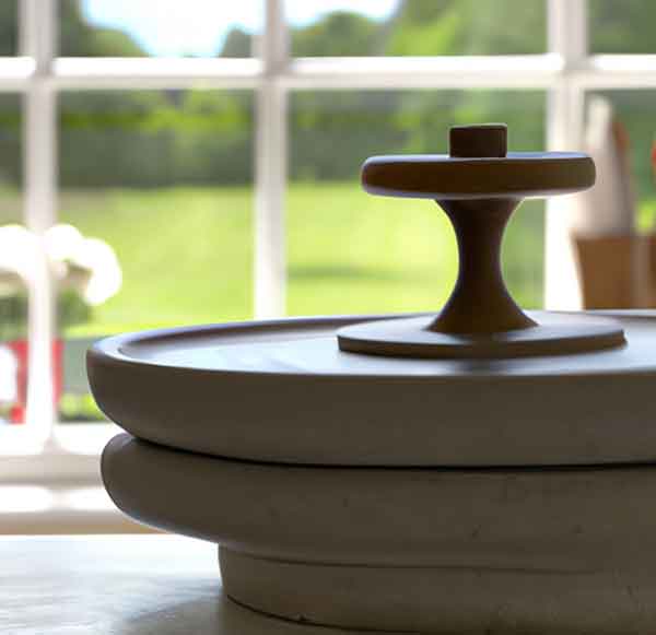 close up view of potter's wheel with the start of a candlestick on it.